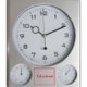 Zilverkleurige kunststof wandklok met thermometer en hygrometer.